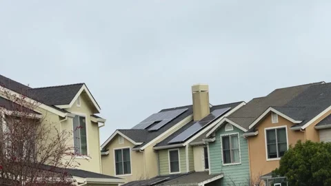 Residential rooftops with solar panels installed under a cloudy sky. Stock Footage 266840858