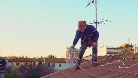 Residential rope access engineer with safety harness working on a roof Stock Footage 125155820