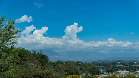 Residential Valley Landscape with Dramatic White Clouds and Blue Sky 库存照片