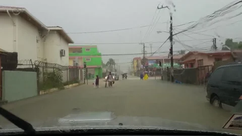Residents walking in deep water downtown during a flood in Belize City. Stock Footage 147994053