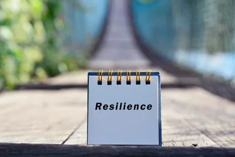 Resilience text written on white note with blurred background of hanging brid Stock Photos