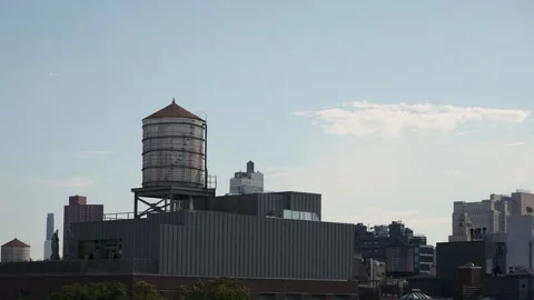 Resilient Industrial Structure Standing Above Brick Warehouse With Distant City Stock Footage 323772870