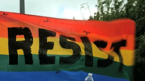 Resist banner Rainbow flag waves blowing Activism slow motion LGBTQ gay pride Stock Footage 75728747