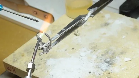 Resizing an Engagement Ring by using a Blow Torch to Melt it Together Stock Footage 93703202