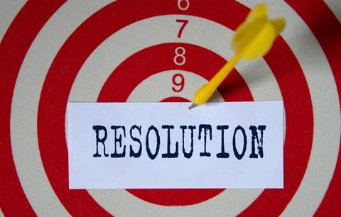 RESOLUTION - word on a white piece of paper on the background of a target for Stock Photos