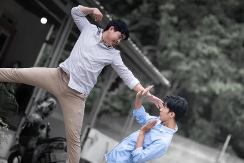 Resolve a problem like a men. A guy punches another man in the face. fight .. Stock Photos