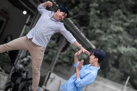 Resolve a problem like a men. A guy punches another man in the face. fight .. Stock Photos