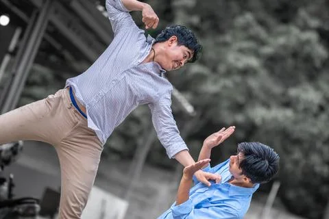 Resolve a problem like a men. A guy punches another man in the face. fight .. Stock Photos