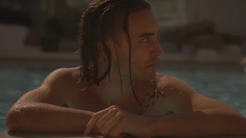 Resort Package 137 | young man with tattoo on arm chest looking around in pool Stock Footage 118525776