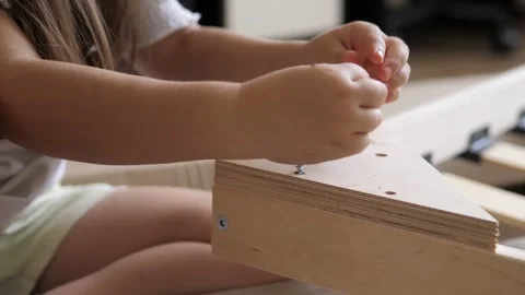 Resourceful smart young 5 years old caucasian girl fastening loose bolt screw in Stock Footage 247368040