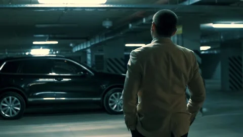 Respectable man in a beige jacket stands opposite a black SUV Video stock 91829290