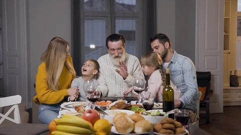 Respected grandfather opening computer on the dinner table and watching on Stock Footage 119587341
