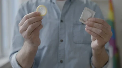 Responsible man holding condom closeup, hiv awareness, conscious family planning Stock Footage 154060790