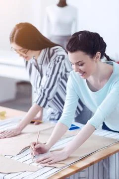 Responsible tailors outlining the sewing patterns Stock Photos