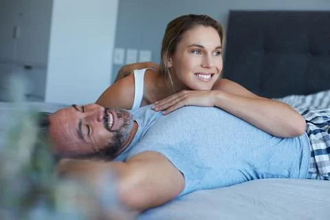Rest, cuddle or couple in bed with hug, connection and bonding together in .. Stock Photos