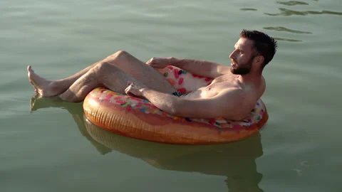 Rest. A man swims on an inflatable ring in a pond. Stock Footage 158193474