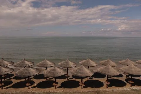 Rest by the sea on the beach with the same umbrellas. Stock Photos