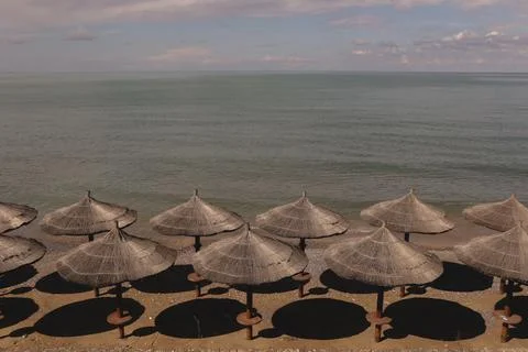 Rest by the sea on the beach with the same umbrellas. Stock Photos