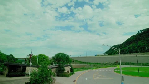 Rest stop with American flag and trucks passing on the highway at a scenic Stock Footage 287199976