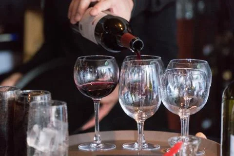 Restaurant bartender server pour bottle of wine into glass for customer drink Stock Photos
