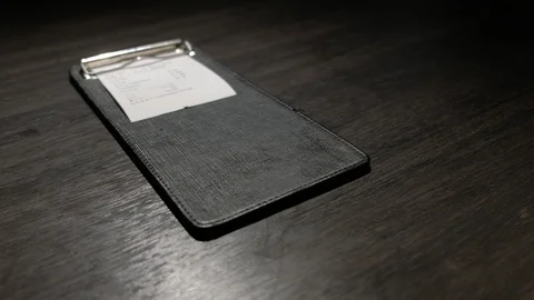 A restaurant bill in the billfold Stock Footage 90764037