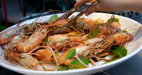 Restaurant buffet seafood take from a large plate shrimp boiled with green Stock Footage 276738017