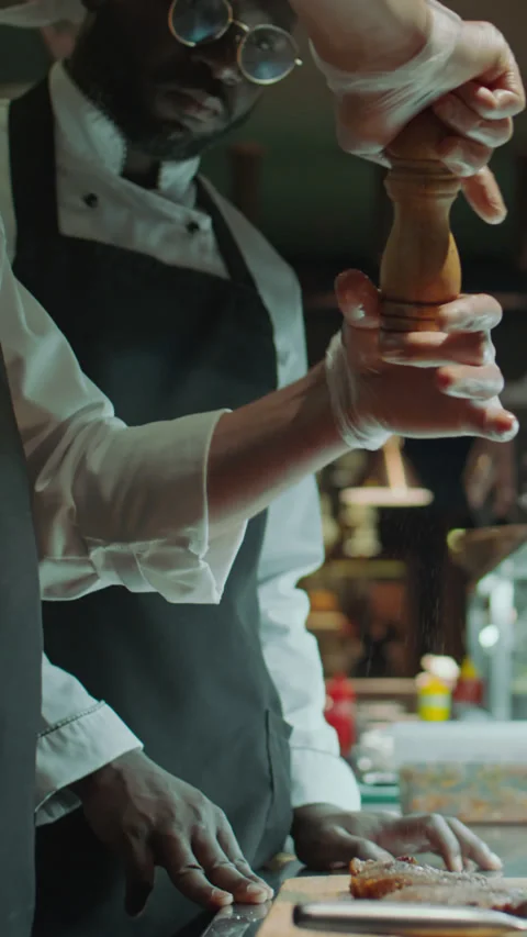 Restaurant Chef Adding Salt and Seasonings to Meat Steaks Stock Footage 273543573