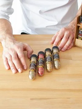 Restaurant chef and a set of jars with different spices in a wooden box in .. Stock Photos
