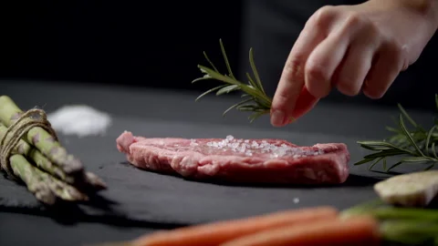 Restaurant Chef Apply Grained Salt And Rosemary Herbs On Raw Piece Of Steak Stock Footage 170241434