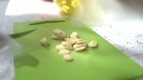 Restaurant chef cuts garlic on plastic cutting board. Chef is wearing gloves. HD Stock Footage 141931913