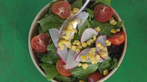 Restaurant chef making salad adding corn on top, top view Video stock 246238006