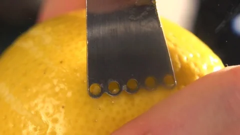 Restaurant chef rubbing a lemon peel on a grater in restaurant kitchen. Close up Video stock 76431024