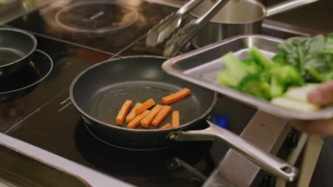 Restaurant Chef Sauteing Broccoli and Carrot in Frying Pan on Stove Stockbeeldmateriaal 330062537