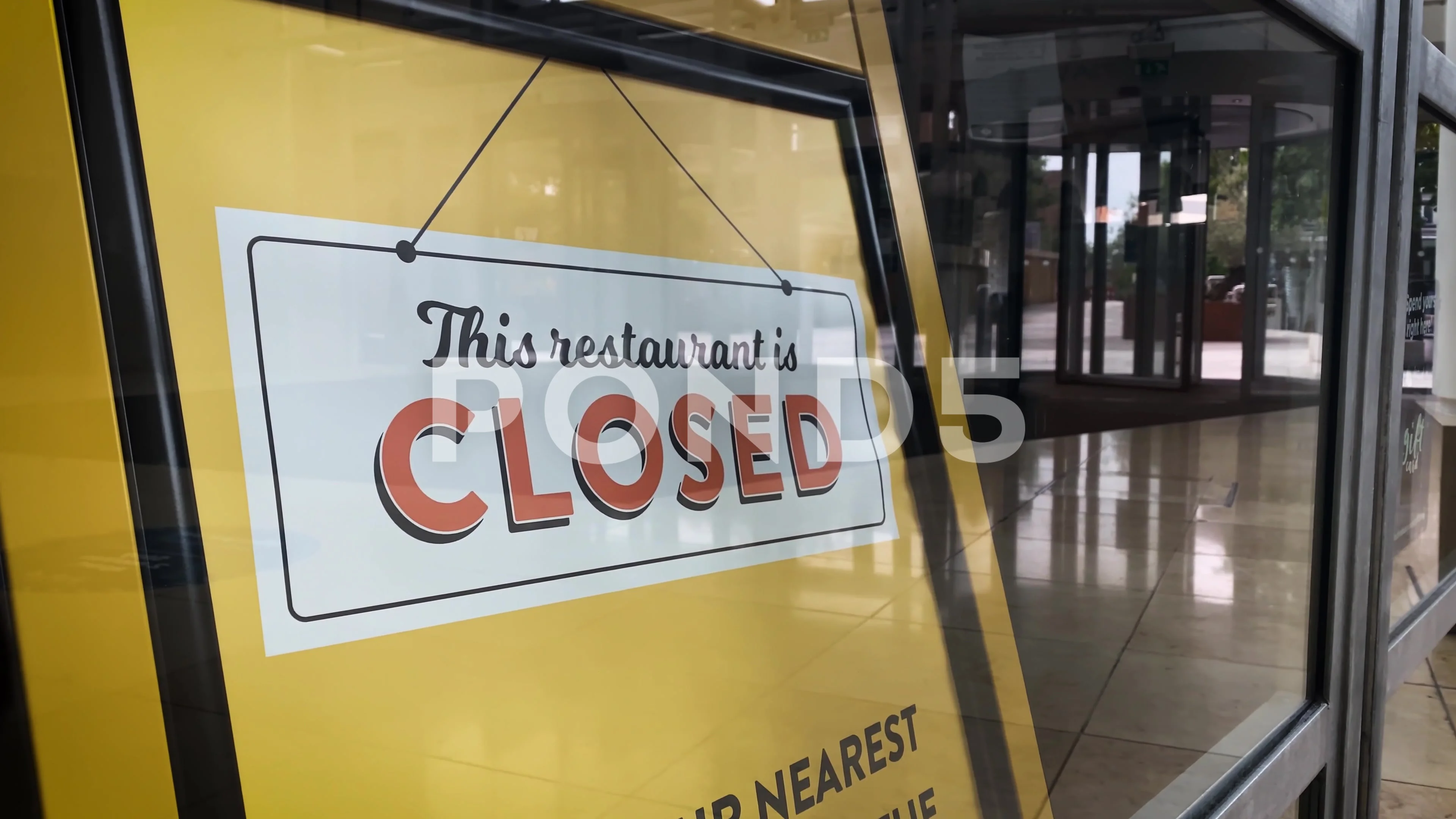 This restaurant is closed sign in shop window in empty shopping centre