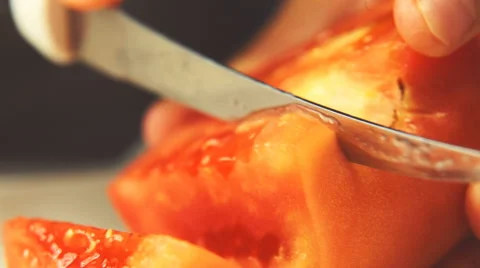 Restaurant cook is slicing tomatoes with sharp knife. Close-up view. Stock-Footage 65522825