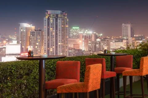 Restaurant dining table and view of business building on terrace at twilight  Stock-Fotos