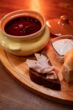 Restaurant dish borscht, delicious bread with bacon, sour cream, bun. A Stock Photos