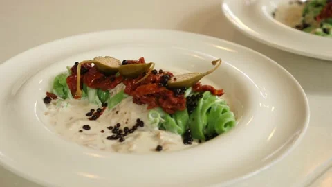Restaurant dish - original serving of green noodles with sun-dried tomatoes and  Stock Footage 239945600