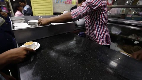 Restaurant employee pours tea from a flash into tea cups Stock Footage 76921407