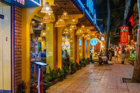 Restaurant Facade with Conical Woven Lanterns on a City Sidewalk at Night Stock Photos