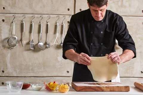 Restaurant hotel private chef preparing pizza rolling flattening dough Foto stock