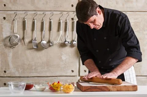 Restaurant hotel private chef preparing pizza rolling flattening dough Stock Photos