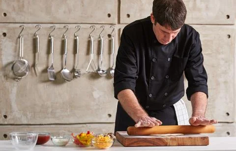 Restaurant hotel private chef preparing pizza rolling flattening dough Stock Photos