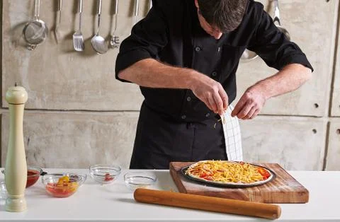 Restaurant hotel private chef preparing pizza adding toppings Foto stock