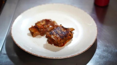 Restaurant kitchen chef cook arranging carefully hot pieces of fried meat pork Stock Footage 106979135