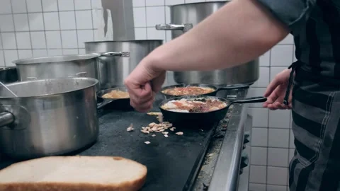 Restaurant kitchen. The chef cooks the sauce. The meat is fried in a frying pan Stock Footage 171682704