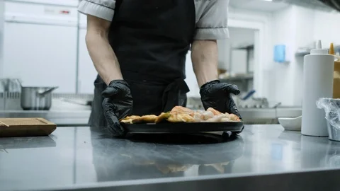 Restaurant kitchen. The chef gives the order a seafood dish to the waiter who Stock Footage 106934672
