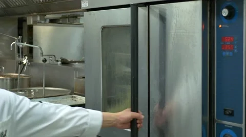 Restaurant kitchen, cook is checking bekon in the industrial oven. Stock Footage 67459848
