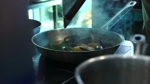 Restaurant kitchen. Frying pan with seafood evaporates, communicates, smokes lot Stock Footage 141305781