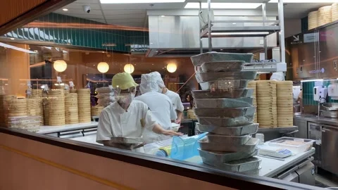 Restaurant kitchen through window chef and helper preparing food and dim sum Stock Footage 281319586